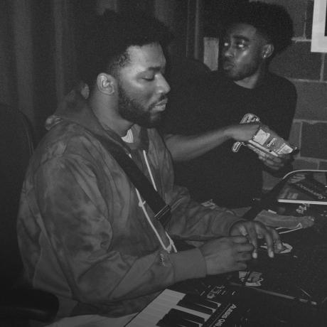 Black and white photo of two men in a recording studio.