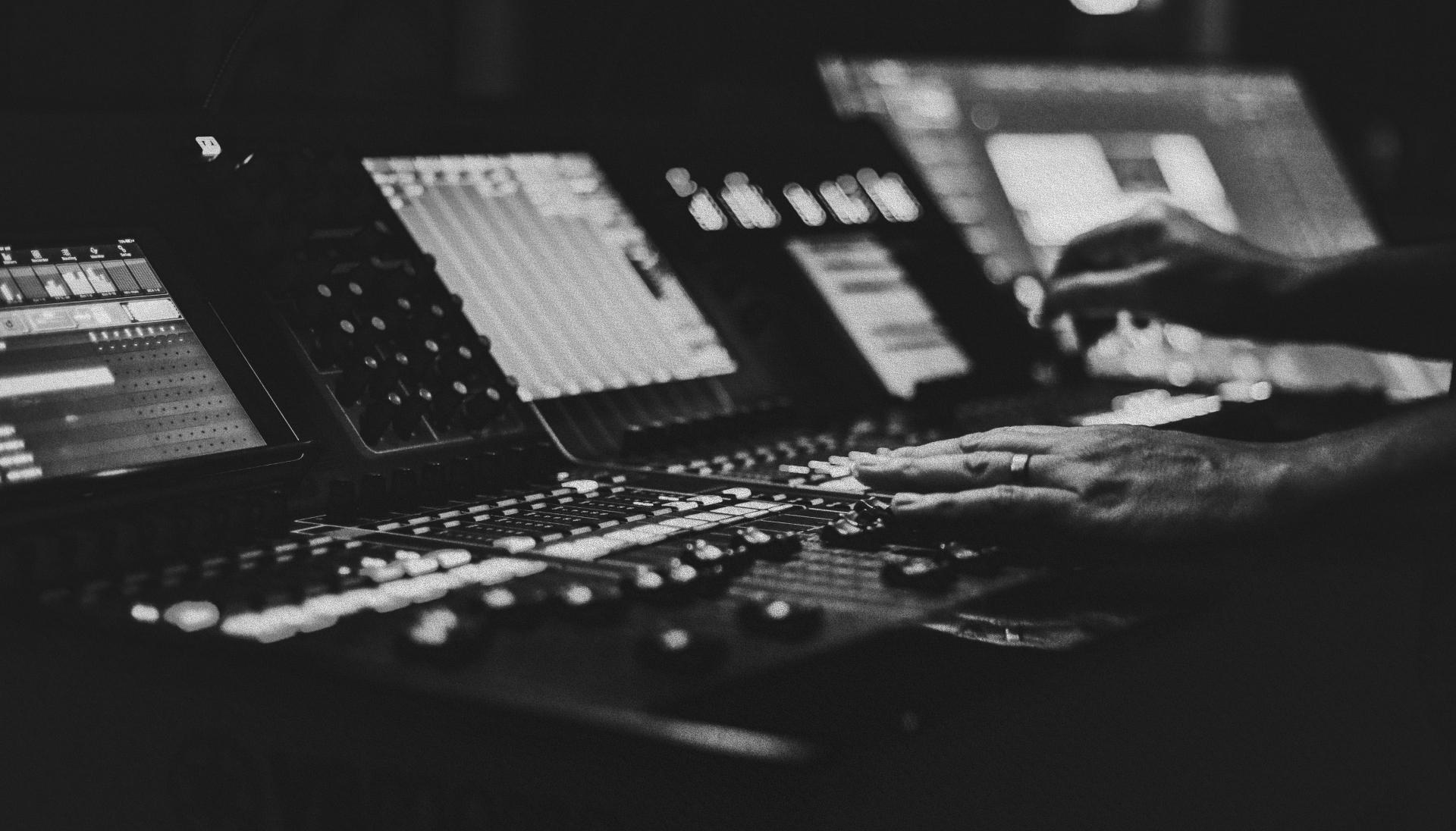 A black and white photo of a person at a mixing desk