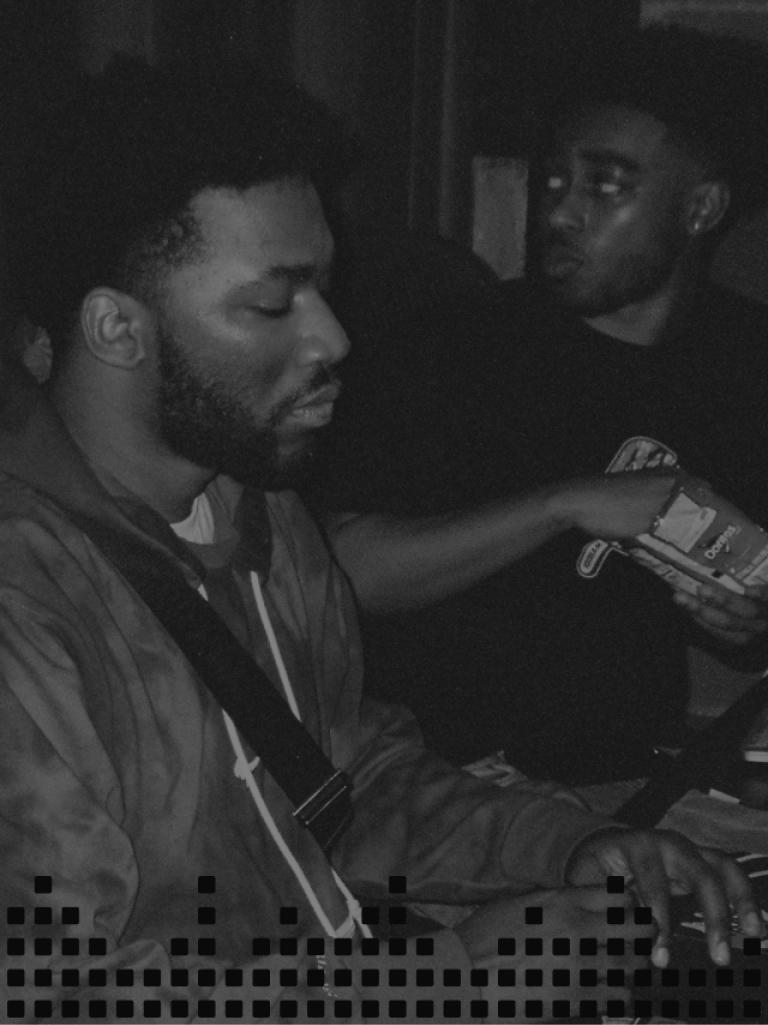 Black and white photo of two men in a recording studio.