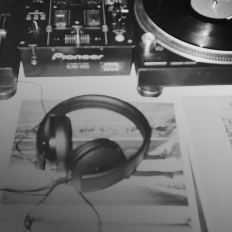 A pair of headphones on a table next to a turntable.