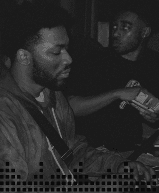 Black and white photo of two men in a recording studio.